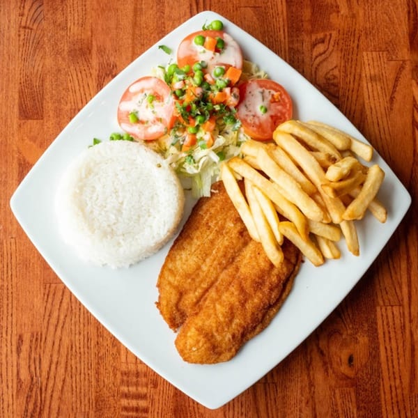 Peruvian fried fish with white rice, french fries, and a fresh salad on a white plate.